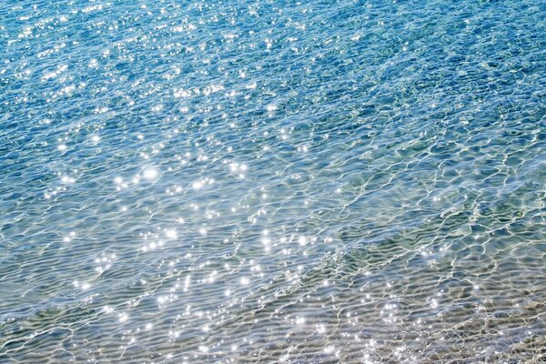 Wellen auf dem Wasser mit Sonnenstrahlen