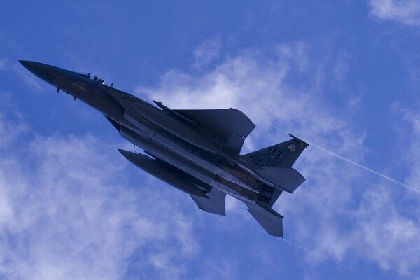 Caza militar ganando altura en el cielo nublado