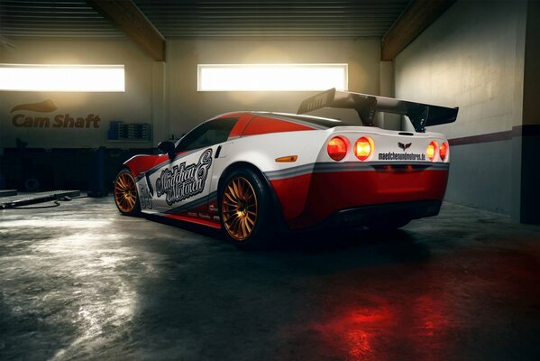 Red and white Chevrolet Corvette in the garage