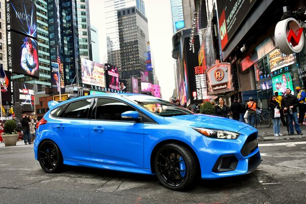 Blue Ford on the background of a crowded city