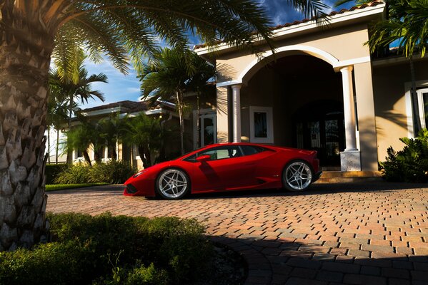 Lamborghini uracan de color rojo en el fondo de la Villa