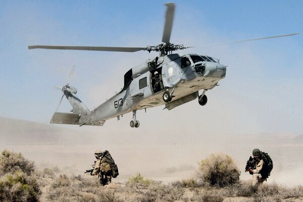 Helicopter over the ground and fleeing soldiers