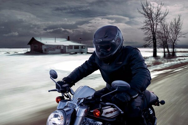 Un hombre con casco en una motocicleta en medio de un paisaje invernal