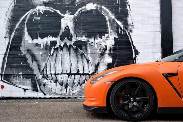 Orange nissan on the background of graffiti