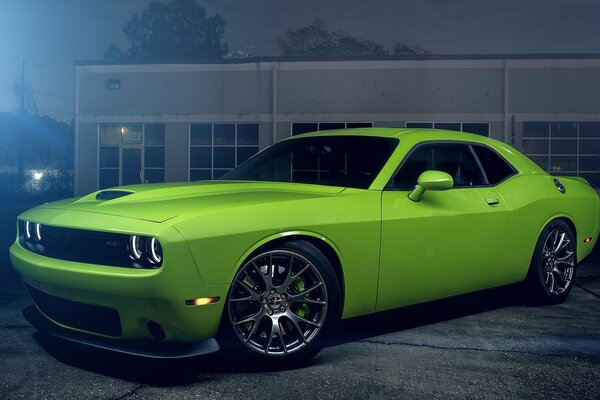 A green American car is parked in the parking lot