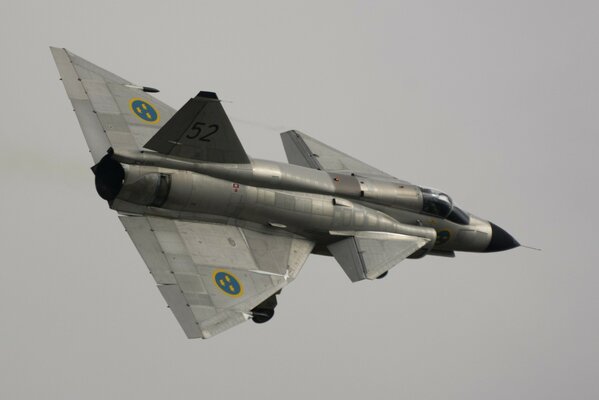 Multicolored fighter jet on a gray sky background