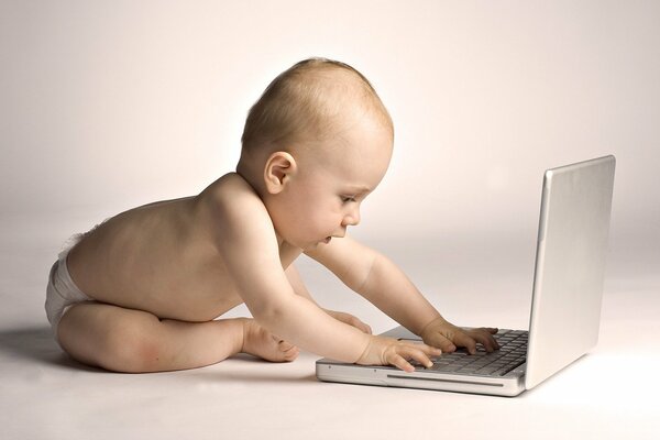 A baby is playing with a laptop