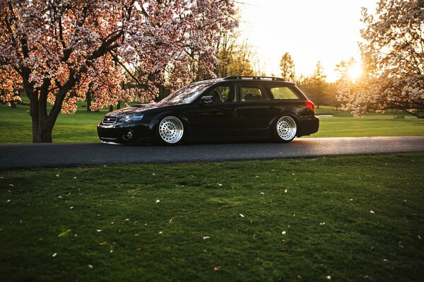 Subaru noir avec des disques blancs sur une journée ensoleillée