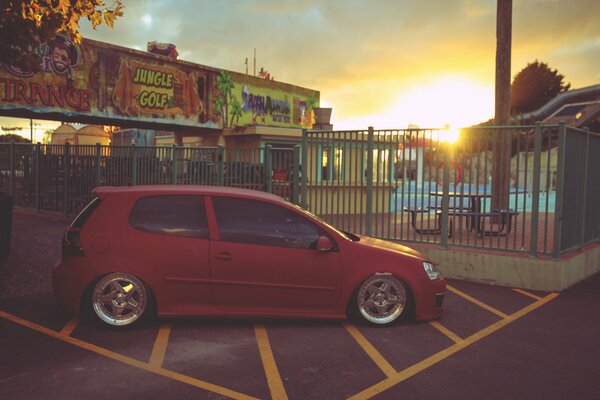 Red Volkswagen Golf on sunset background