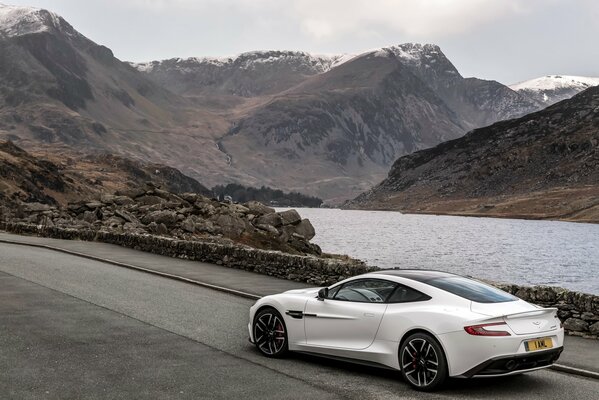 Un coche blanco corre por la pista en medio de las montañas