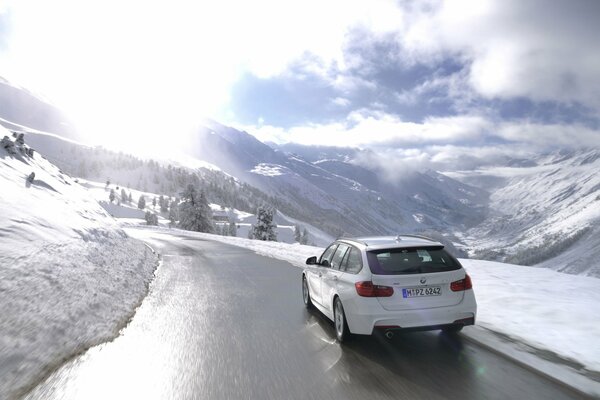 Une BMW blanche roule sur une route d hiver