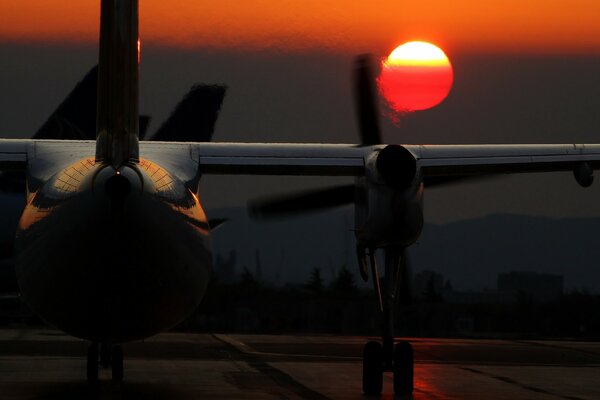 The plane takes off from the aerodrome at sunset