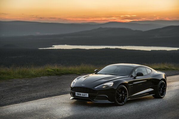 The car is black against the background of mountains and rivers