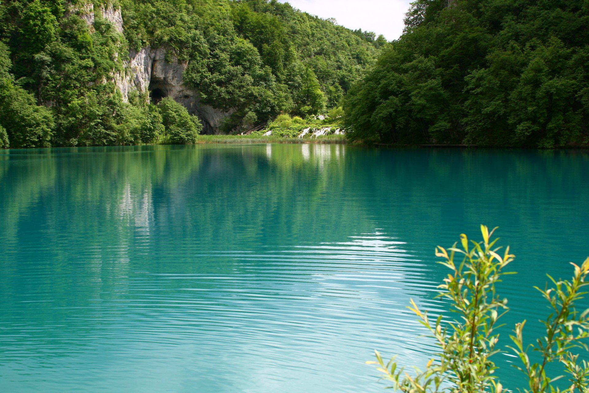 lago paesaggio verde acqua natura acqua verde turchese superficie liscia riva vegetazione montagne boschetti