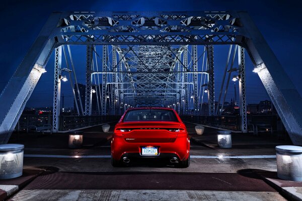 Coche rojo de noche en el puente