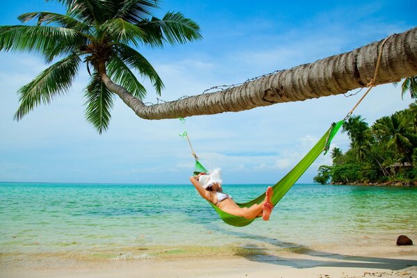 Fille au repos dans un hamac sur la plage