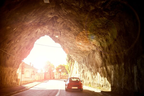 Porsche esce dal tunnel nella roccia in una giornata di sole