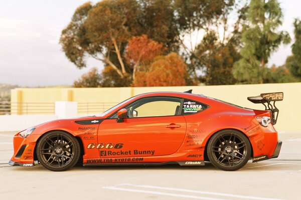 An orange sports car is on the road