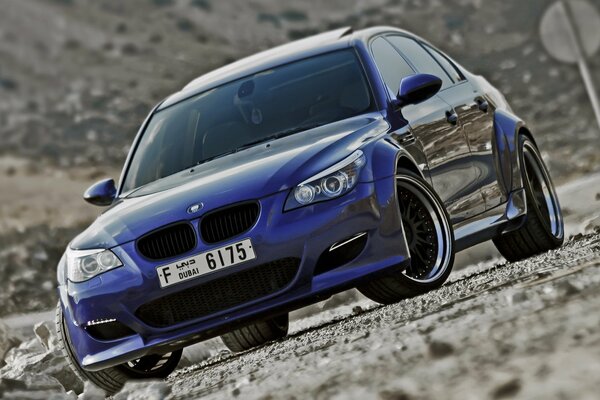 BMW M5 tuning se trouve sur le bord de la route avec des gravats