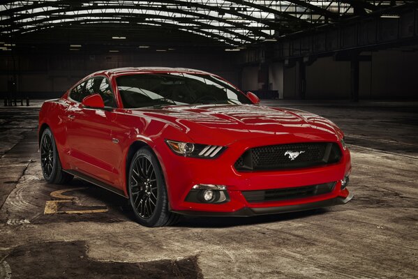 Ein roter Ford Mustang in einer Flugzeuggarage