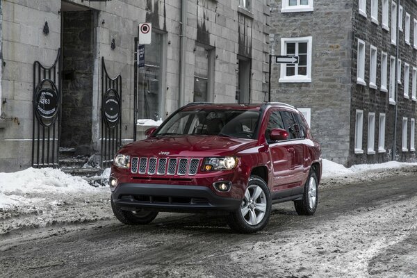 Czerwony samochód firmy Jeep stoi na środku ulicy