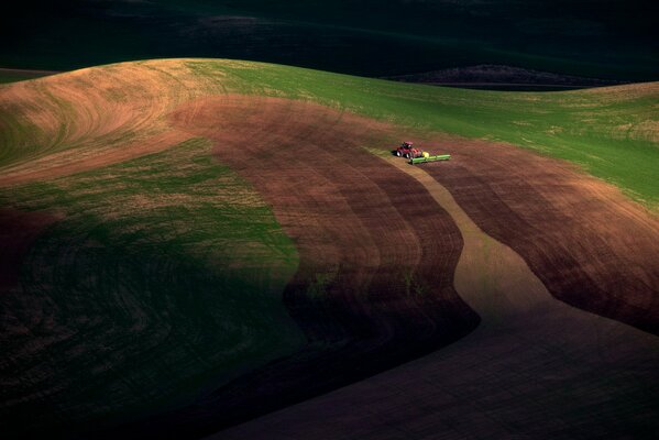 Photo prise d en haut, le champ où travaille le tracteur, crépuscule