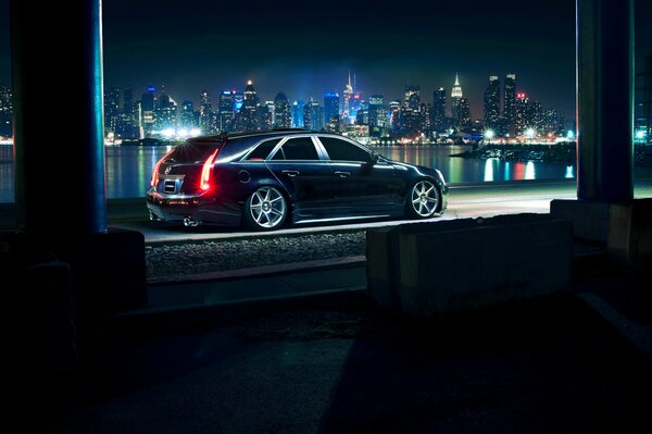 Schwarzer Cadillac auf Nacht Stadt Hintergrund