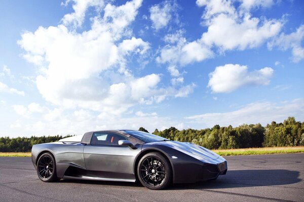 A supercar on a training track. Forest and blue sky in the background