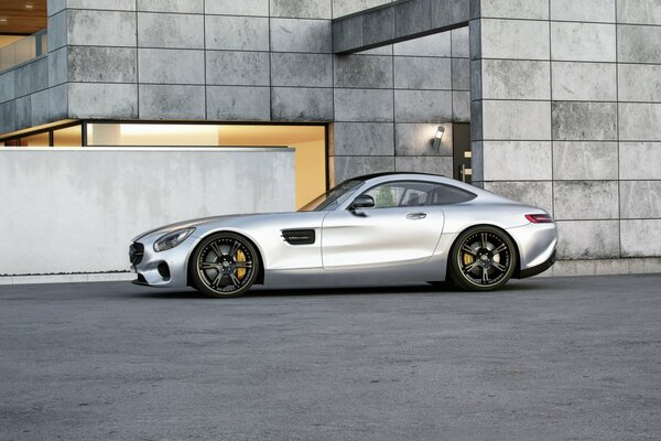 Silver Mercedes on the background of an urban building