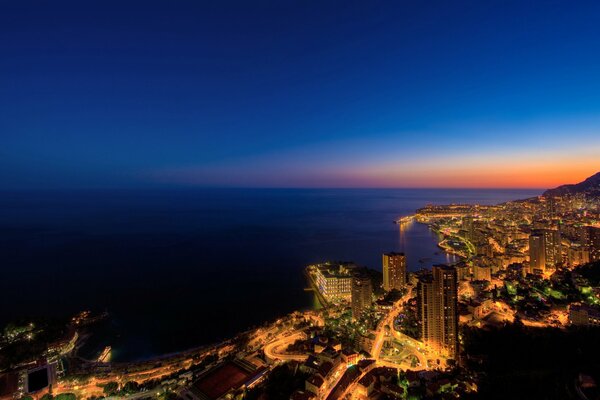 La ciudad nocturna brilla junto al mar