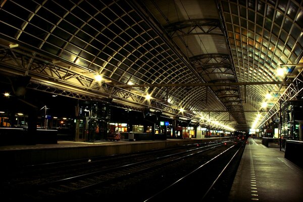 Gare de nuit des chemins de fer dans les lumières