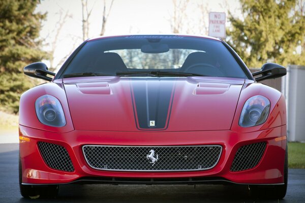 Roter Sportwagen Nahaufnahme. Ferrari in roter Farbe auf einem Hintergrund von Bäumen