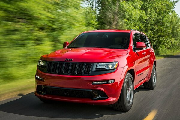 Ein roter breiter Jeep rast über die Strecke