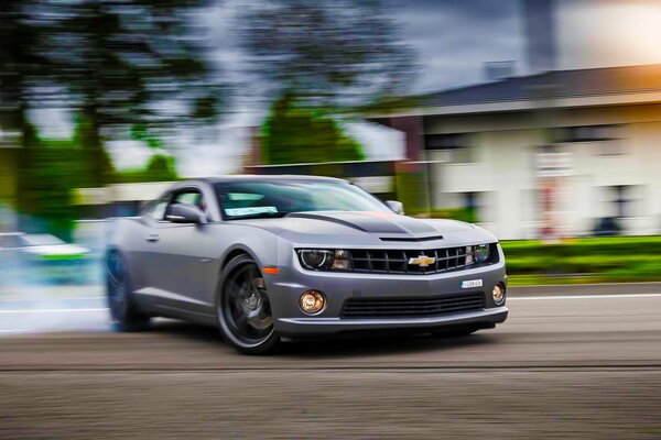 Fast drift of a grayish-colored car