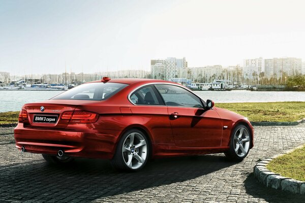 Paesaggio urbano con auto rossa BMW