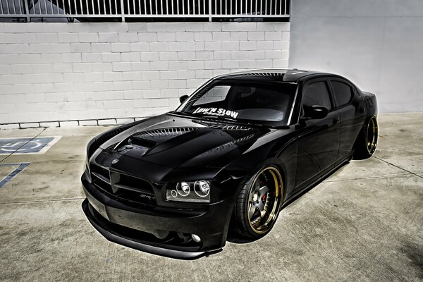 Black Dodge Charger on a gray wall background