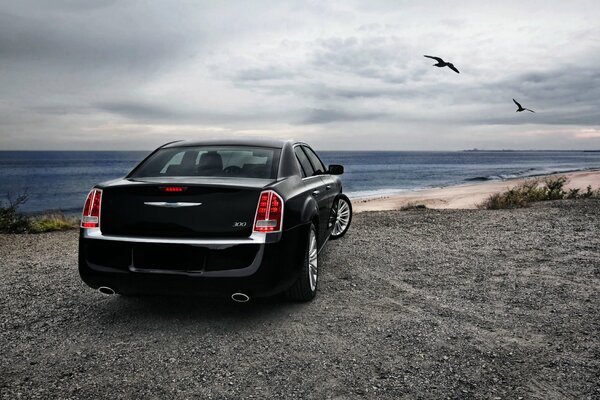 Black Chrysler sedan near the coast