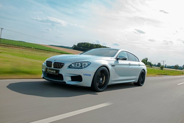 A white bmw car rushes down the road