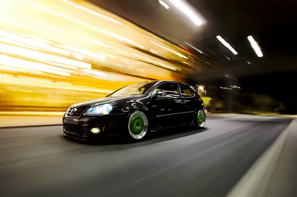 Un hermoso Volkswagen negro corre por la ciudad de la noche