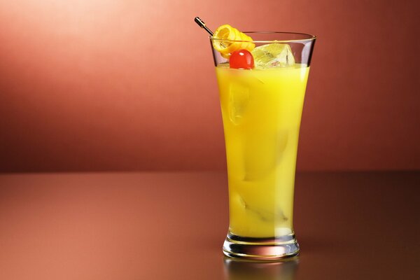 Cóctel de frutas con hielo en un vaso alto