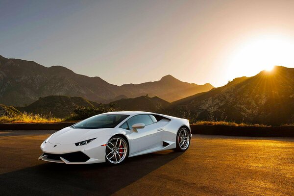 Lamborghini Uracan blanco en el fondo de la puesta de sol entre las montañas