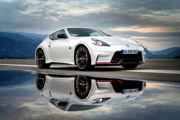 Nissan mit Himmel in Wolken und Reflexion im Wasser