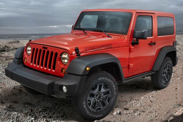 Red Jeep rangler on the rocks