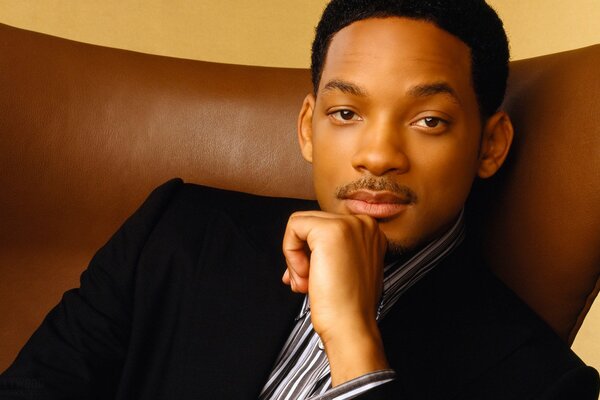 El actor will Smith se sienta en una silla marrón