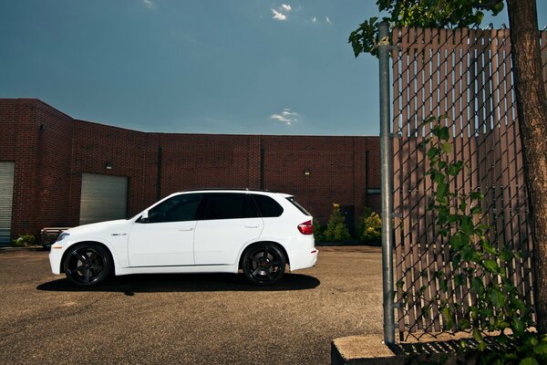 BMW X-5 white crossover near the building