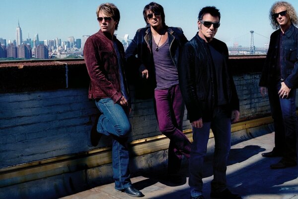 A quartet of stylish rock musicians in dark glasses