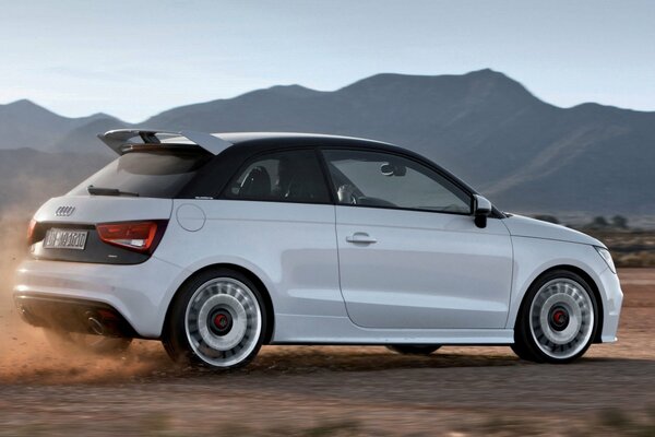 Audi a1 едет по дороге в гористой местности