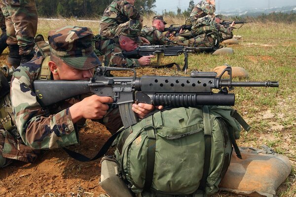 Soldiers with machine guns and backpacks at the training ground