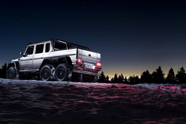 Silver merc with three axles on snow four-wheel drive