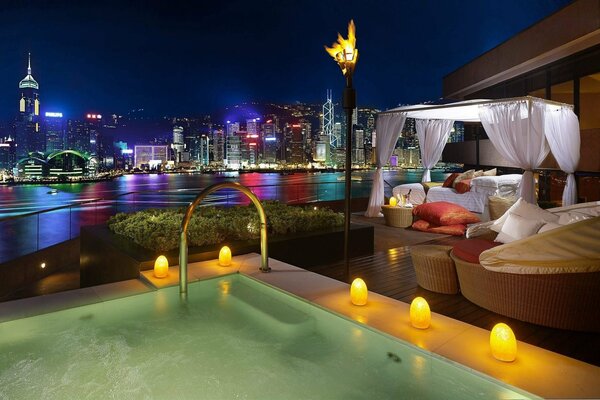 Cozy gazebo by the pool in the night lights of the city